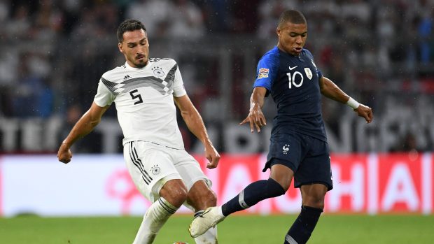 Obránce Německa Mats Hummels (v bílém) v soubji s mladým francouzským útočníkem Kylianem Mbappém