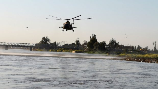 Helikoptéra irácké armády pátrá nad řekou Tigris po přeživších na místě kde se trajekt potopil