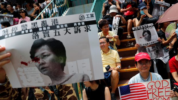 Někteří demonstranti drží plakáty s obrázkem správkyně Hongkongu Carrie Lamové