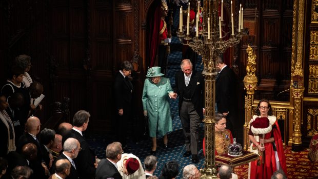 Britská královna v doprovodu prince Charlese vchází na půdu parlamentu, aby zahájila nové zasedací období a přednesla plán vlády.