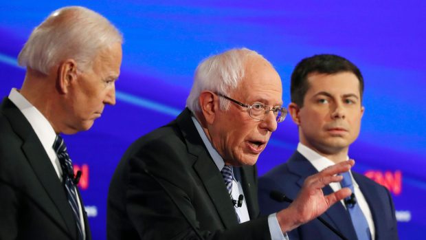 Bývalý viceprezident Joe Biden (vlevo) a někdejší starosta ze státu Indiana Pete Buttigieg (vpravo) poslouchají senátora Bernieho Sanderse během poslední debaty demokratů před primárkami