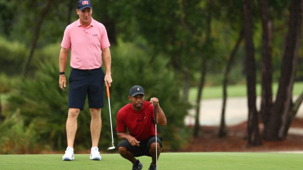 Tiger Woods (v pokleku) během golfové exhibice na Floridě se svým spoluhráčem Peytonem Manningem