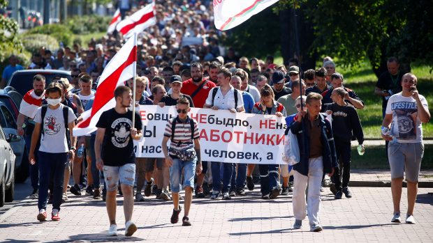 Demonstrace v továrně na výrobu traktorů v Minsku (MZKT). Na transparentu stojí: „Nejsme ovce. Nejsme stádo. Jsme pracovníci MTZ a není nás dvacet, ale 16 000.&quot;