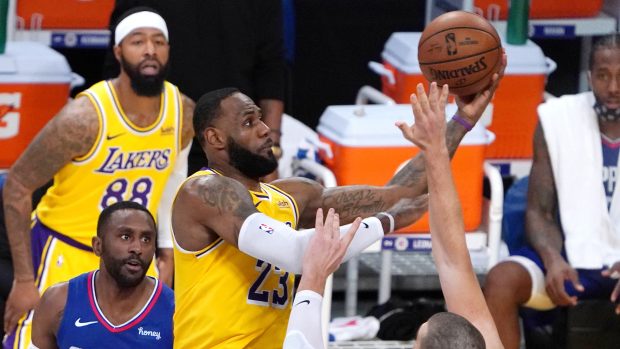 LeBron James z Lakers (uprostřed s míčem) bojuje s bránícími hráči Clippers.