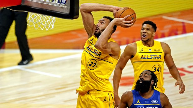 Rudy Gobert z týmu LeBrona Jamese smečuje v Utkání hvězd. Přihlíží jeho spoluhráč Janis Adetokunbo a James Harden z týmu Kevina Duranta