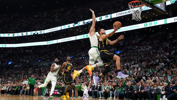 Stephen Curry se snaží dát koš, brání mu Jayson Tatum