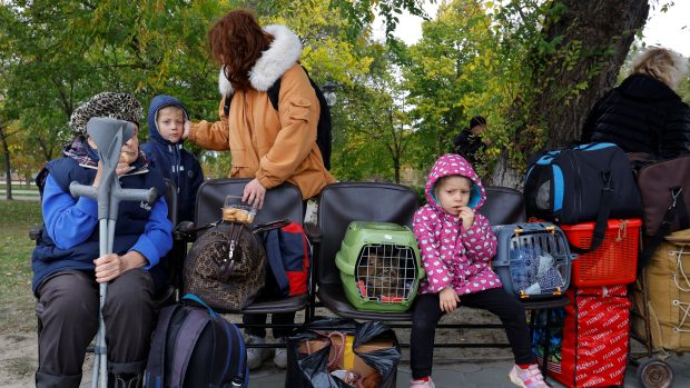 Civilisté, kteří uprchli z Chersonu, čekají na autobus. Míří na Krym