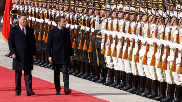 Čínský prezident Si Ťin-pching a francouzský prezident Emmanuel Macron hodnotí vojáky během oficiálního ceremoniálu ve Velké síni lidu