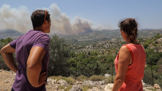 Švýcarští turisté hledí na požáry u vesnice Archangelos na Rhodosu