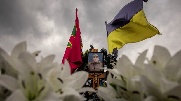 Ukrajinská vlajka nad hrobem judisty Stanislava Hulenkova. Ukrajina posílá na olympiádu 140 sportovců, truchlí nad 488 zabitými