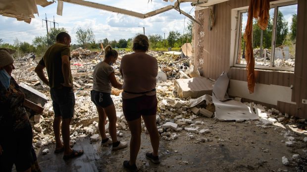 Obyvatelé vyklízejí dům ve vesnici v Kyjevské oblasti, který byl těžce poškozen během masivního útoku ruských raket a dronů na Ukrajinu (11. srpna 2024)