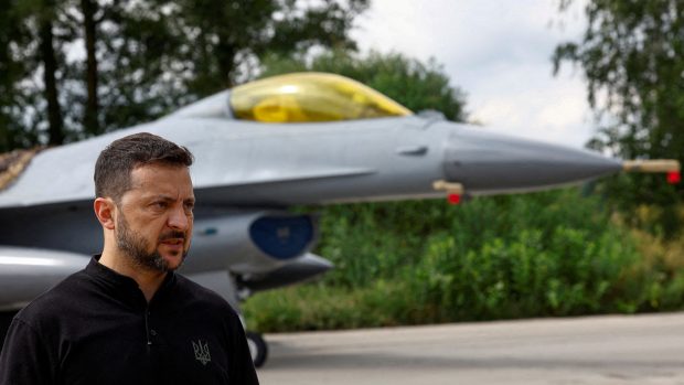 Ukrajinský prezident Zelenskyj hovoří s médii před bojovým letounem F-16 po oslavách Dne ukrajinského letectv