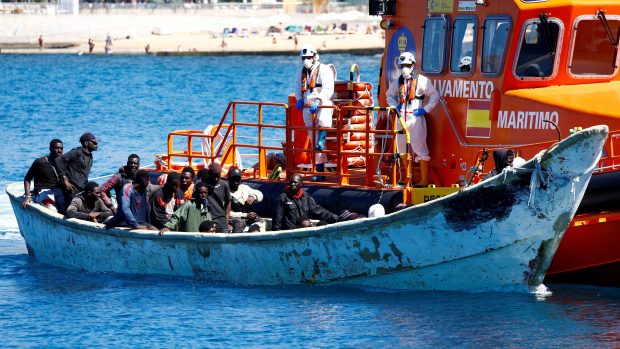 Migranti čekají na vylodění z lodi v přístavu Arguineguin na ostrově Gran Canaria