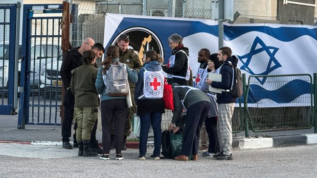 Pracovníci Červeného kříže čekají na příjezd tří propuštěných rukojmích