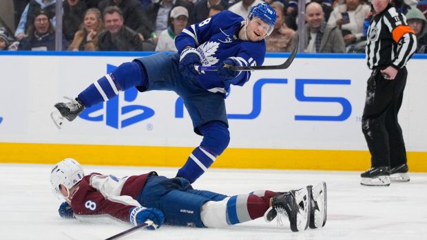 Útočník Toronta Maple Leafs Steven Lorentz (18) vstřelil vítězný gól přes roztaženého obránce Colorada Avalanche Calea Makara (8) během třetí třetiny ve Scotiabank Areně, 19. března 2025, Toronto.