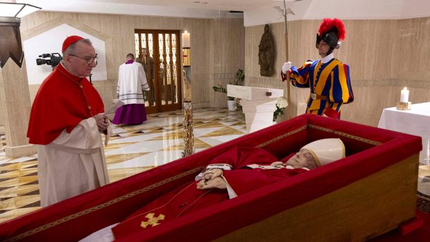 Kardinál Pietro Parolin stojí u těla papeže Františka uloženého v otevřené rakvi během obřadu prohlášení za mrtvého v rezidenci Santa Marta ve Vatikánu, 21. dubna 2025