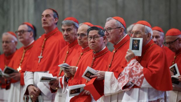 Kardinál Luis Antonio Tagle, kardinál Pietro Parolin a další kardinálové stojí v den předání bohu těla papeže Františka v bazilice svatého Petra ve Vatikánu.