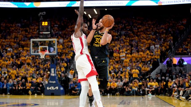 Stephen Curry z Golden State střílí přes blokujícího Tariho Easona z Houstonu