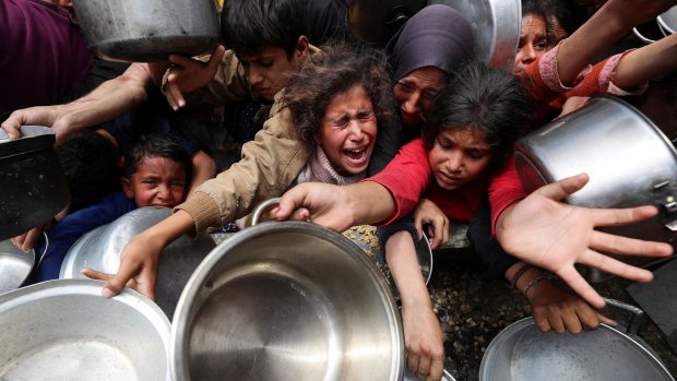 Palestinci čekající na jídli z charitativní kuchyně na snímku z dubna 2025