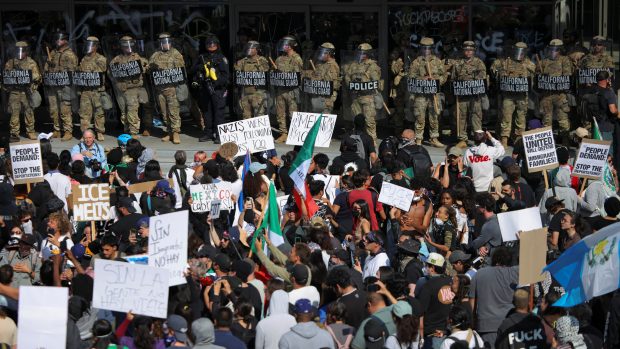 Demonstranti před budovou v Los Angeles, v níž sídlí řada federálních úřadů, nesli transparenty jako: „Stojím za všemi migranty“. Vchod střežili policisté a příslušníci Národní gardy