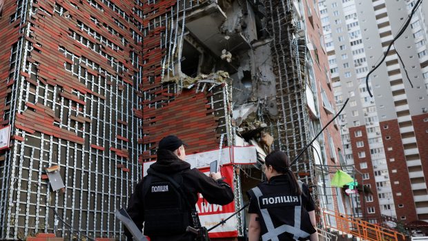 Policejní vyšetřovatelé stojí u domu poškozeného po ruském útoku v Kyjevě (fotografie z 10. června 2025)