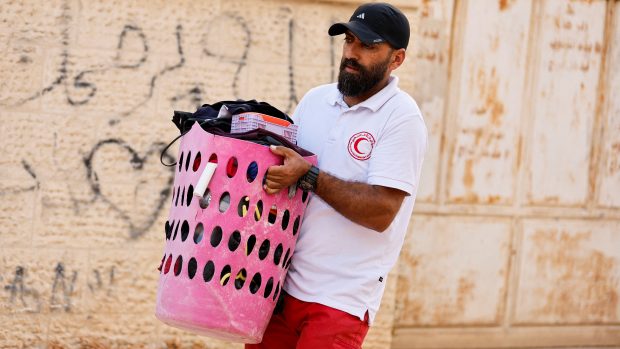 Paramedik pomáhá Palestincům přenášet osobní věci během izraelské vojenské operace nedaleko uprchlického tábora Jenin na Izraelem okupovaném Západním břehu Jordánu (8. července 2025)