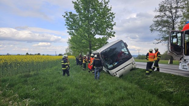 Autobus skončil v příkopě na boku opřený o strom