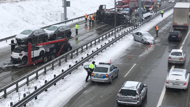 Na Pražském okruhu před nájezdem na D5 ve směru od sjezdu z Barrandova se převrátil kamion převážející osobní automobily. Na místě jsou pražští hasiči.