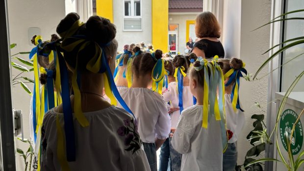 Děti i rodiče oblékli vyšyvanky – vyšívané košile, dívky mají ve vlasech modrožluté stužky