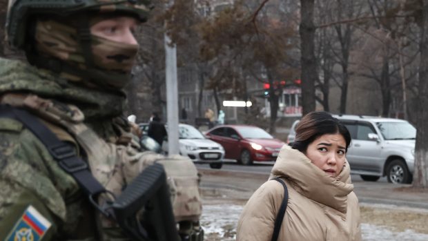 Obyvatelka Almaty prochází kolem ruského vojáka, zástupce „mírových jednotek“ Organizace Smlouvy o kolektivní bezpečnosti