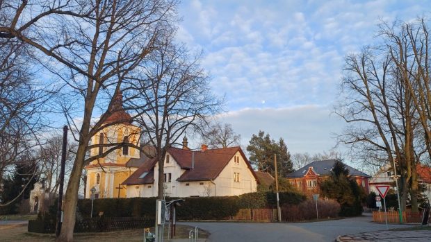 Náves v Oknech s kostelem, v pozadí je červená budova prvního stupně