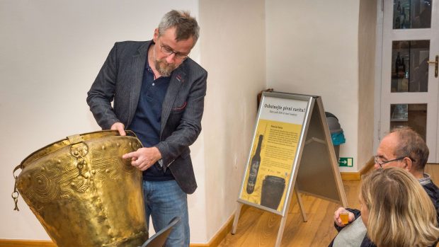 Ředitel Východočeského muzea v Pardubicích Tomáš Libánek ukazuje symboly na bronzovém vědru, kde byly zbytky piva