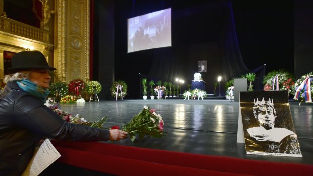 Lidé pokládají květiny na pódium Národního divadla.
