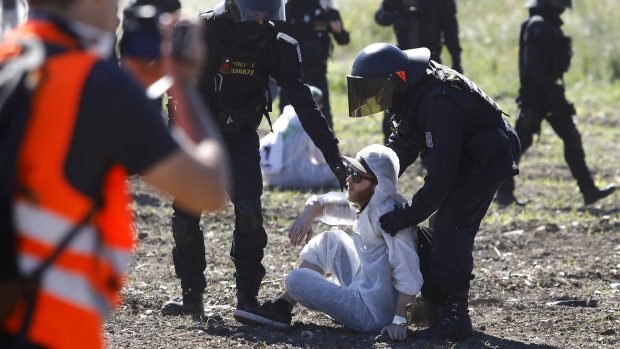 Dopoledne během protestního pochodu vybočily nečekaně zhruba dvě stovky lidí z vymezené trasy a pokusily se proniknout do lomu Bílina. Na místě je obklopili policejní těžkooděnci.