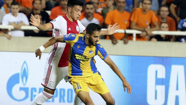 Hráč APOELu Nikósie Musa Suleimanduring si brání míč před Lisandrem Martinezem z nizozemského Ajaxu