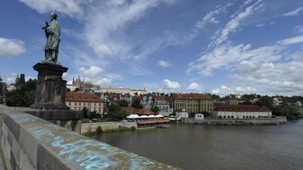 Modré nápisy v angličtině jsou na pravé straně zábradlí směrem k Pražskému hradu asi od poloviny mostu