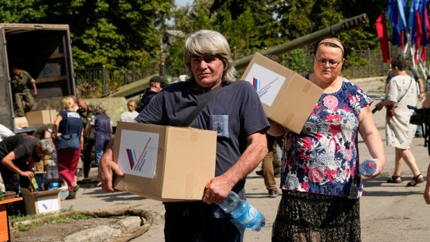 Místní obyvatelé dostávají humanitární pomoc vedle výstavy ukořistěných ukrajinských tanků a dalších zbraní v Lysyčansku na území, které je pod kontrolou vlády Luhanské lidové republiky