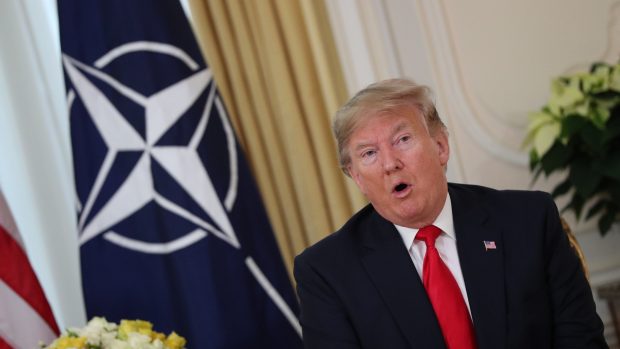 Donald Trump s vlajkou NATO v pozadí