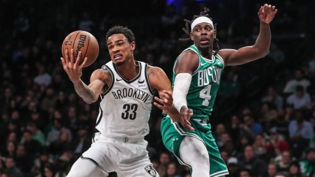 Pivot Brooklynu Nic Claxton v souboj s rozehrávačem Bostonu Jrue Holidayem