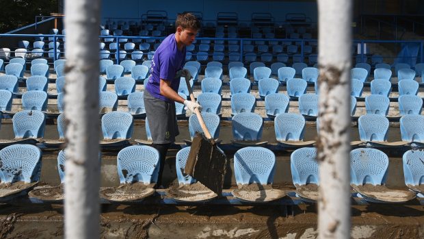 Dobrovolník uklízející škody po povodních na opavském stadionu