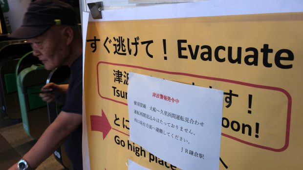 Varování před tsunami a výzva k evakuaci cestujících na nádraží ve městě Kamakura na japonském ostrově Honšú