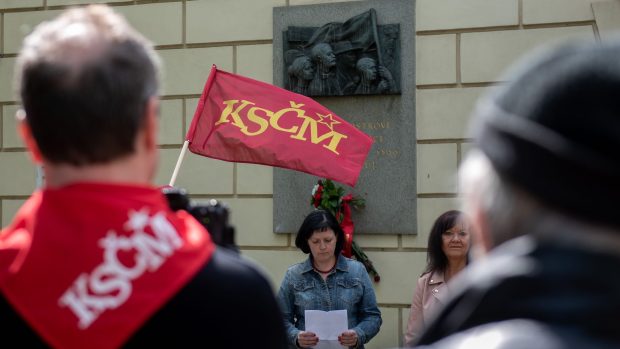 Na akci komunistů vlály vlajky strany. Napravo předsedkyně pražské buňky KSČM Marta Semelová