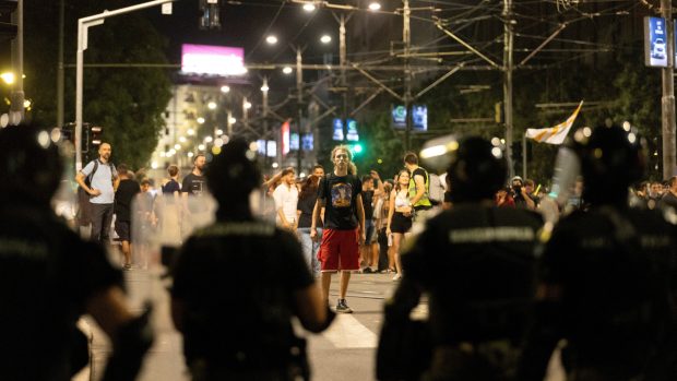 Protestující stojící proti těžkooděncům během demonstrací v Bělehradě