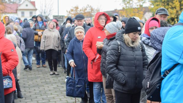 Uprchlíci čekají před farou na výdej humanitární pomoci