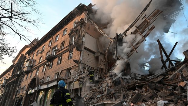 Záchranáři pracující v troskách budovy zničené ruským raketovým útokem