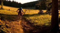 Biker projíždí po singletracku při západu slunce