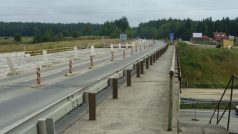 Chodníček na kraji mostu přes dálnici D3 na jednom konci končí v poli a na druhém prochází okružní křižovatku