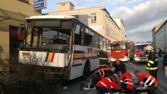 Záchranáři ošetřují zraněné po dopravní nehodě autobusu a trolejbusu.