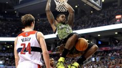 Toronto Raptors forward Amir Johnson hangs off the basket after dunking the ball in front of Washington Wizards defender Jan Veselý during the first half of their NBA basketball game