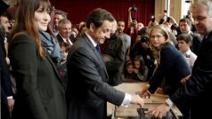 Současný francouzský prezident Nicolas Sarkozy odevzdává svůj hlas v prezidentských volbách spolu se svojí manželkou Carla Bruni-Sarkozy